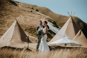 Gather and Gold hire teepee tent - bride and groom outside teepees
