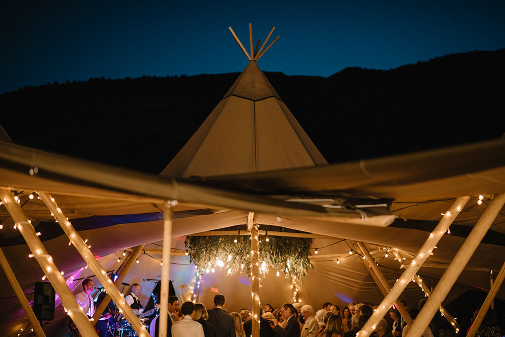 Tipi wedding by Gather and Gold - wedding reception with guests dancing in large lit tipi