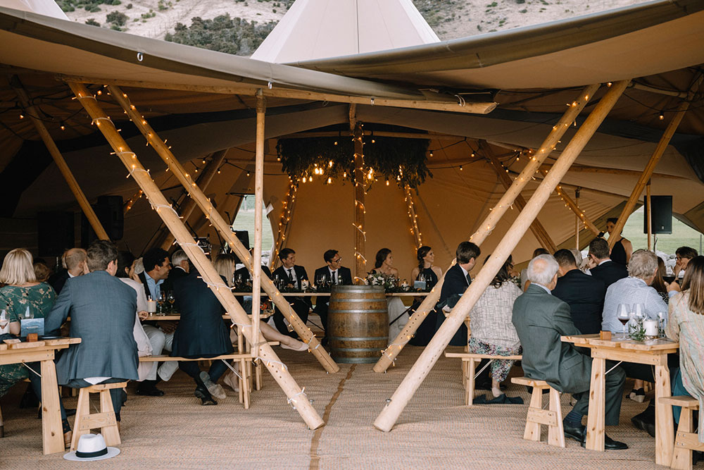 Tipi wedding by Gather and Gold - wedding reception with guests seated for speeches in large furnished tipi