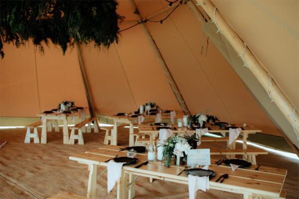 Gather and Gold large teepee tent hire - table and bench seats inside a giant tipi