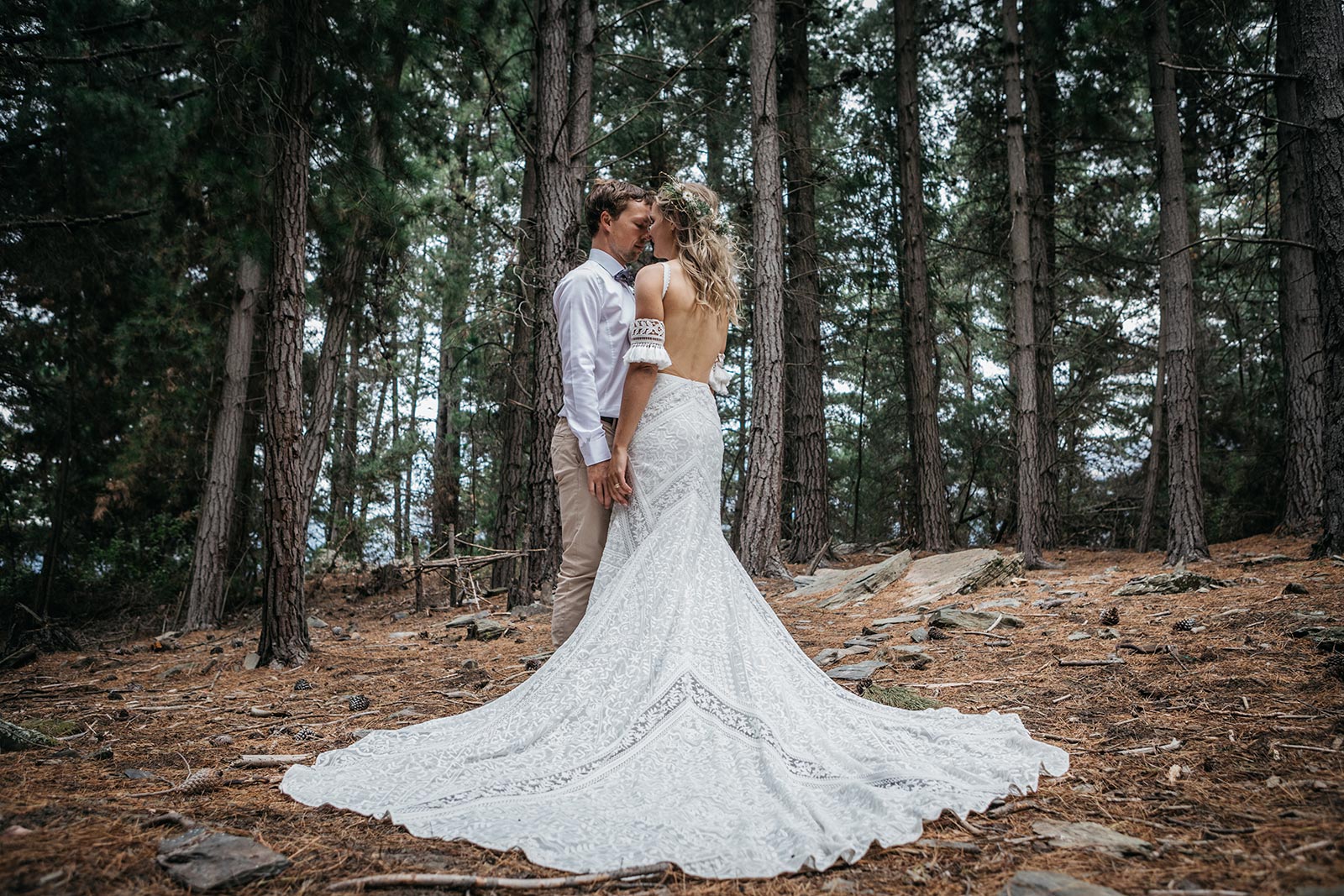 Gather and gold teepee wedding tent - bride and groom in a forest in Queenstown, bride wearing an off shoulder dress with a beautiful long train