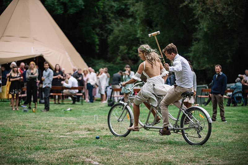Wanaka tip wedding by Gather & Gold - bride and groom play croquet on a twin bike
