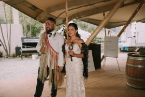 Gather and Gold nordic tipis - bride and groom wearing traditional wedding attire entering tipi together