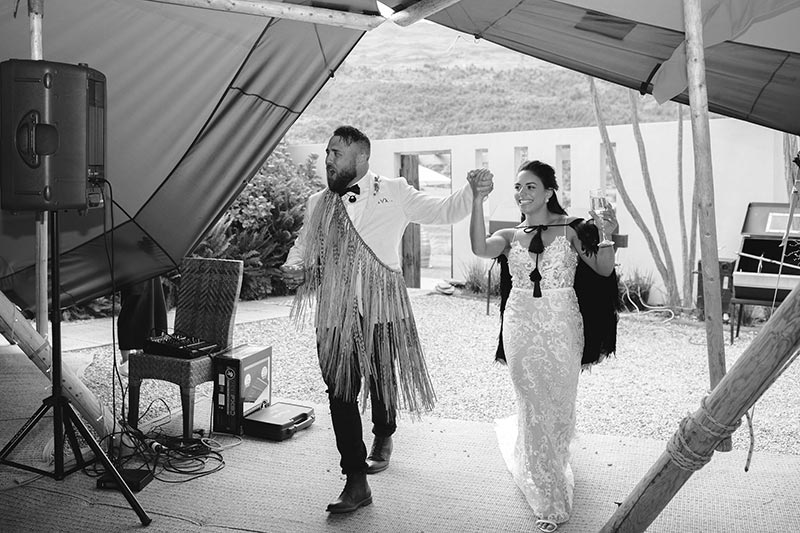 Black and white photo of bride and groom entering tipi at wedding reception - tipi wedding by Gather and Gold
