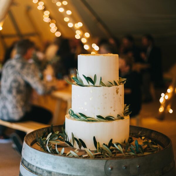 Gather and Gold teepee hire - wedding cake inside teepee on a wine barrel
