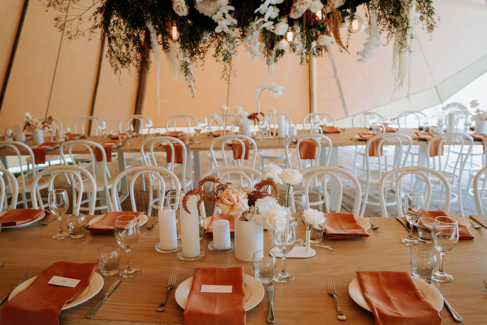 Wedding table settings and flowers in a Gather and Gold tipi