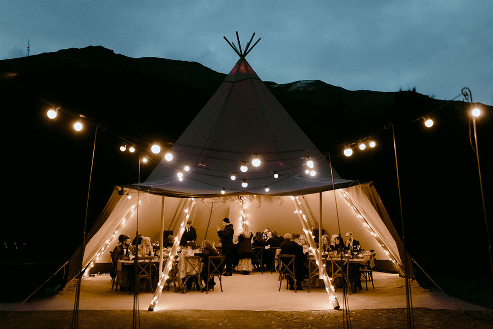 Beautiful Gather and Gold tipi with festoon lighting at night. 