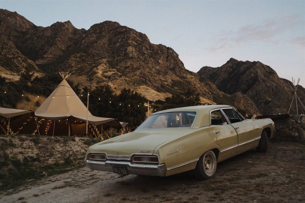 Fairytale tipi wedding in Hawea, South Island, New Zealand. Tipi tents with fairy lights. Classic car. 