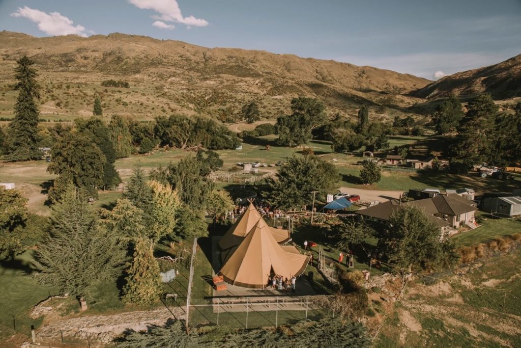 Aerial view of two tipis nestled amongst some trees