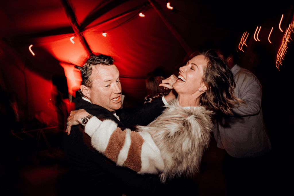 A man dances with a woman in a tipi