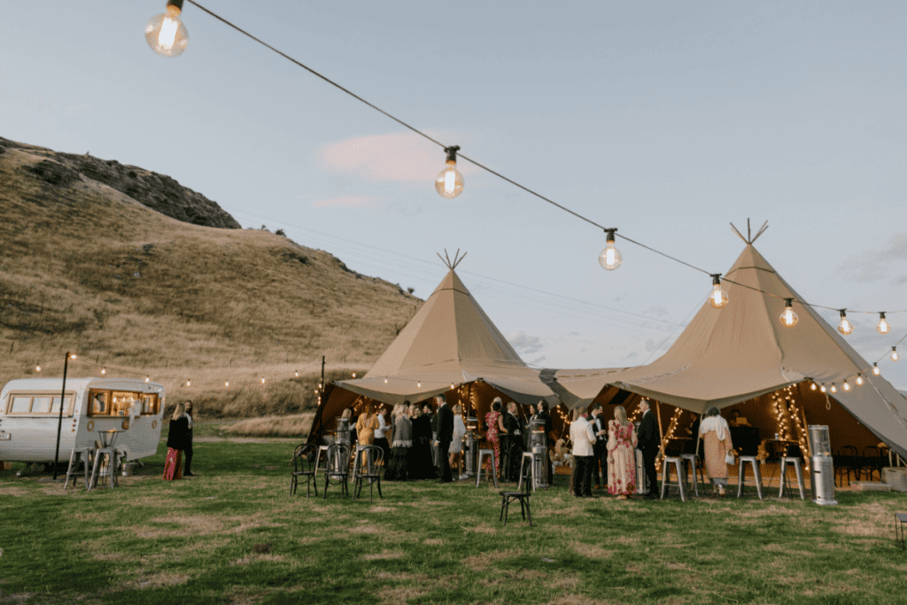 Nordic tipis under mountains in New Zealand next to a caravan bar